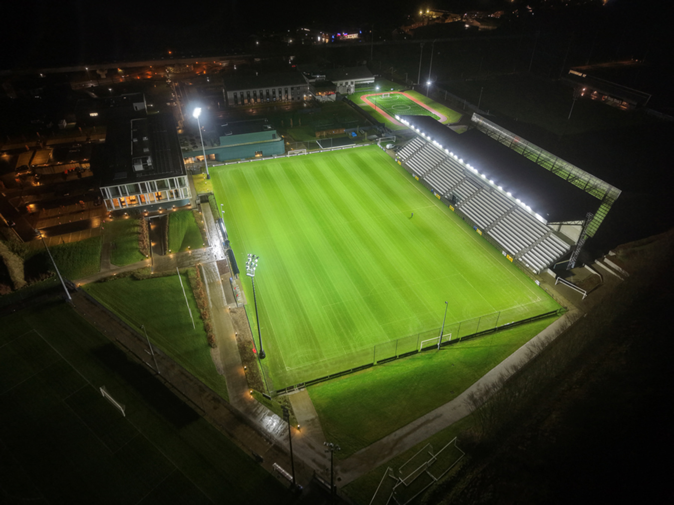 Aerial view of the Proximus Basecamp training pitch illuminated by Lumosa LED sports lighting for professional football training.