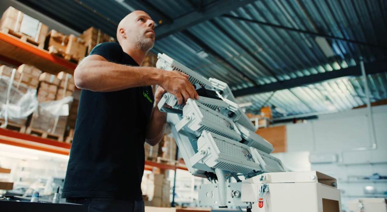 Lumosa employee aligning LED luminaire in the facility